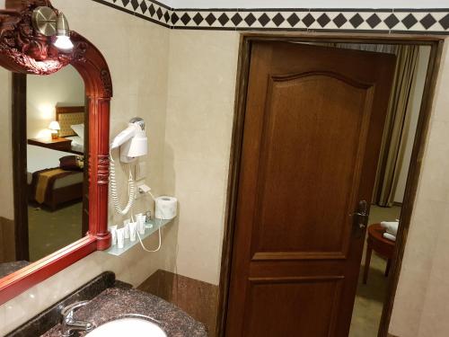 een badkamer met een wastafel, een spiegel en een deur bij Rezydencja Pod Zegarem in Trzebinia