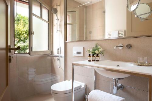 La salle de bains est pourvue d'un lavabo, de toilettes et d'un miroir. dans l'établissement Villa du Pyla, à Pyla-sur-Mer