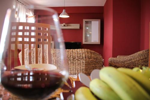 a table with a glass of wine and a bunch of bananas at Poseidone Sea Apartment Taormina in Mazzeo