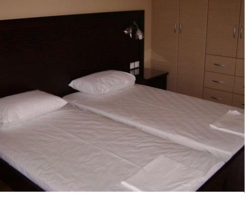 a large white bed with two pillows on it at Pantheon Hotel & Suites in Nerotriviá