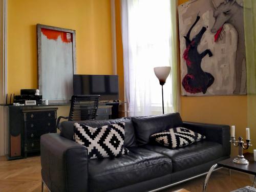 un soggiorno con divano in pelle e TV di Basilica Central Apartment a Budapest