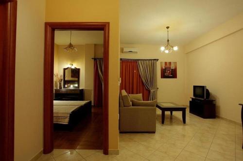 a living room with a bed and a couch and a television at Pantheon Hotel & Suites in Nerotriviá