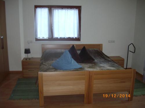 a bedroom with a wooden bed with a window at Casa Simona in Sorafurcia