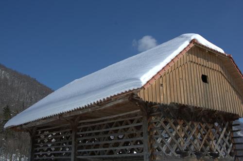 a snow covered roof on top of a cabin at Guesthouse Močivnik in Okroglice