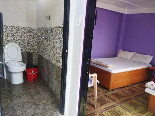 uma pequena casa de banho com uma cama e um WC em City View Home Stay em Tānsen