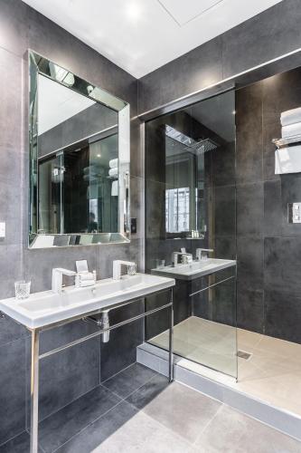 a bathroom with two sinks and a mirror at The Inn on the Mile in Edinburgh