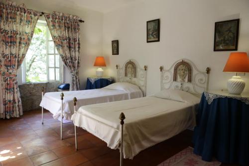 um quarto com duas camas e uma janela em Casa da Figueira Velha em Resende