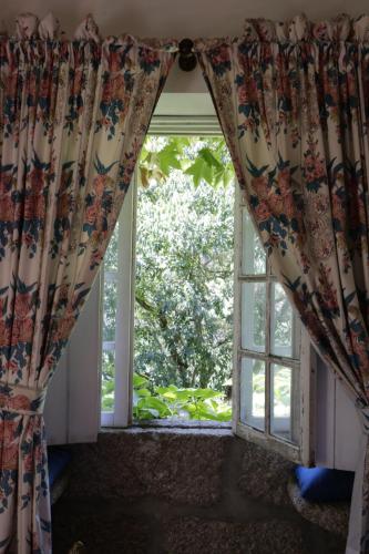 an open window with a curtain in a room at Casa da Figueira Velha in Resende
