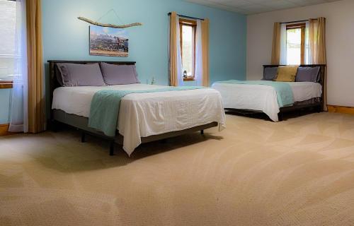 2 letti in una camera da letto con pareti blu di The Hive Lodge-with views of the Smokies a Whittier