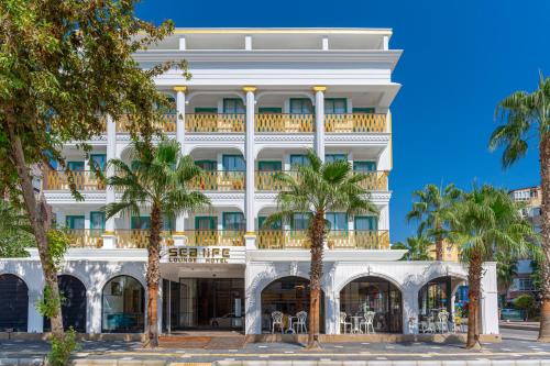 a hotel with palm trees in front of it at Sealife Lounge - Adult only in Antalya