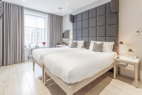 a bedroom with a large bed with a large headboard at The Inn on the Mile in Edinburgh