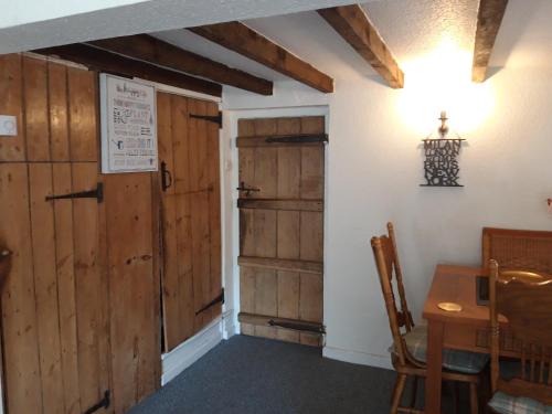 a room with a wooden door and a table at rosedale cottage in Walsgrave on Sowe