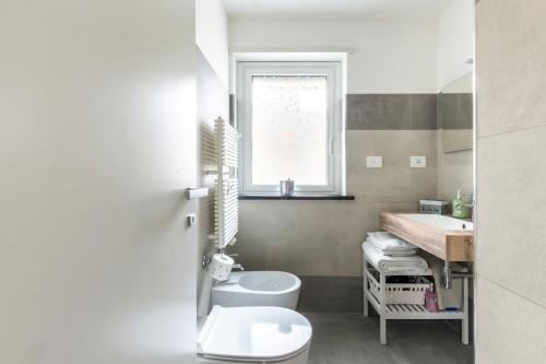 a bathroom with a toilet and a sink and a window at LIVING ROME Int 2 in Rome
