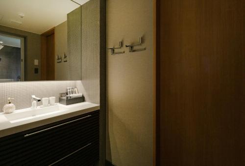 a bathroom with a sink and a mirror at MATERIAL Fuchomae in Kyoto