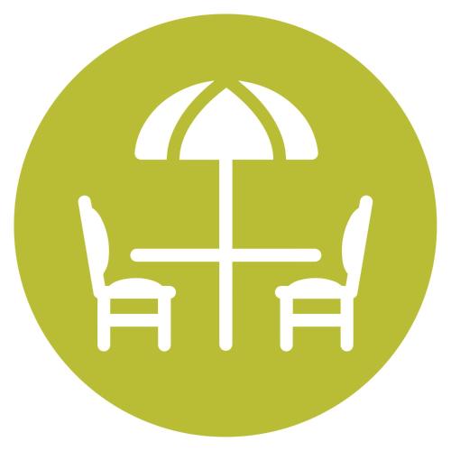 a table and chairs with an umbrella and a table and chairs at Abbey Apartments Modern ApartHotel for Tourists & Professionals in Barrow in Furness