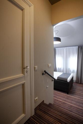 a room with a bed and a door leading to a bedroom at Hotel Cēsis in Cēsis