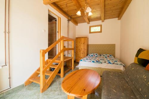 uma sala de estar com uma cama e uma mesa de madeira em Ancsa Vendégház em Visegrád
