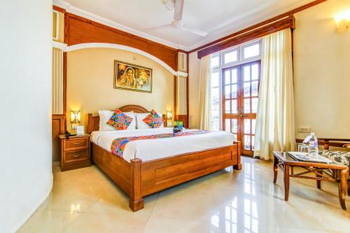 1 dormitorio con cama y ventana grande en Sunset Beach Resort, en Candolim