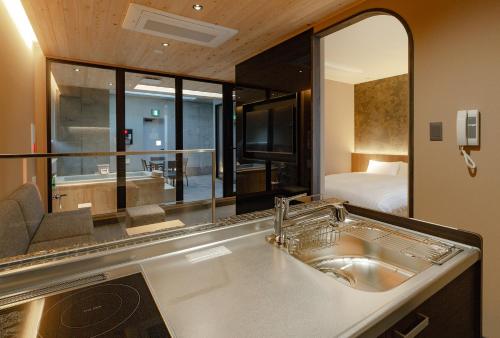 a bathroom with a sink and a large mirror at MATERIAL Fuchomae in Kyoto