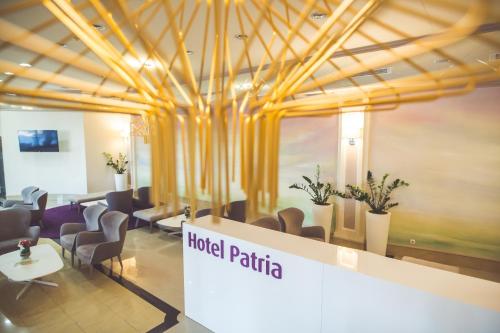 a lobby of a hotel patria with chairs and tables at Hotel Patria in Beli Manastir