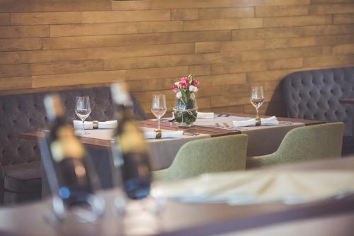 a table with wine glasses and flowers on it at Hotel Patria in Beli Manastir