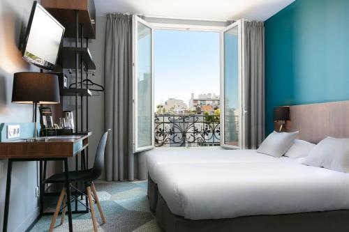 a hotel room with a bed and a desk and a window at Montparnasse Alésia in Paris