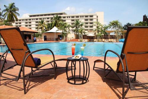 two chairs and a table in front of a pool at The Federal Palace Hotel and Casino in Lagos