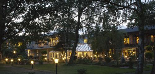 un bâtiment avec des lumières devant lui la nuit dans l'établissement Landhotel Stähle, à Schüttorf