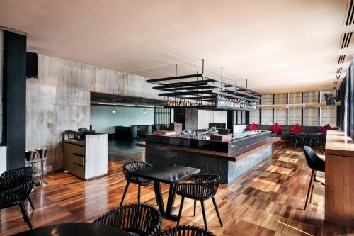 a restaurant with tables and chairs and a kitchen at Welcomhotel by ITC Hotels, Dwarka, New Delhi in New Delhi