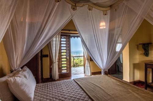 1 dormitorio con 1 cama con cortinas y ventana en SaffronStays Villa 270, Dapoli, en Dapoli