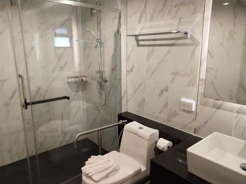 a bathroom with a shower and a toilet and a sink at Hotel De Sripoom in Chiang Mai