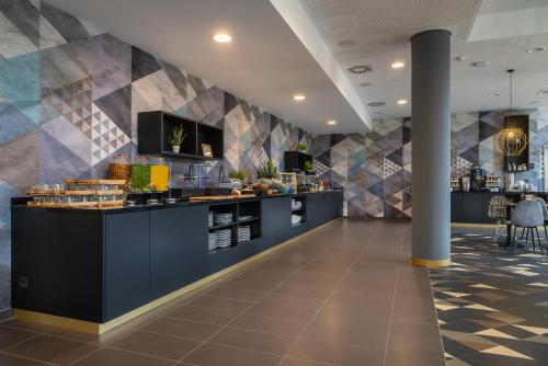 a restaurant with a counter in a room at Holiday Inn - the niu, Ridge Halle Central Station by IHG in Halle an der Saale