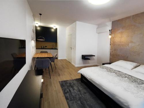 a bedroom with a bed and a table and a desk at Come&Stay apartments Wola in Warsaw