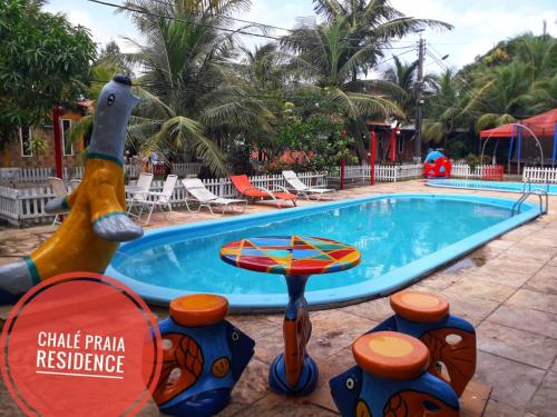una piscina en un complejo con un perro y una mesa en Chale Praia Residence, en São Luís