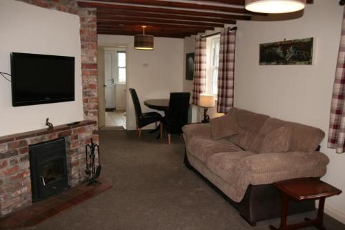 a living room with a couch and a fireplace at Hawthorn in Crayke YO61 4TE in York