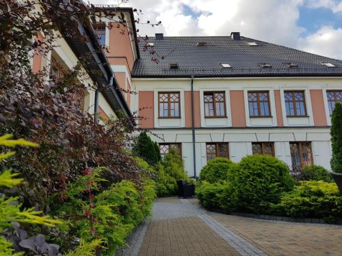 a building with a tile roof and a courtyard at Rezydencja Pod Zegarem in Trzebinia