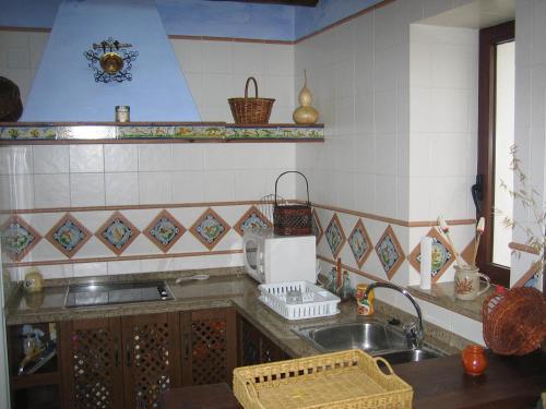 una cocina con fregadero y microondas en Casa Rural La Villa, en Castro del Río