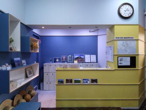 a store with a clock on a blue wall at Slow Citi Guest House in Seogwipo