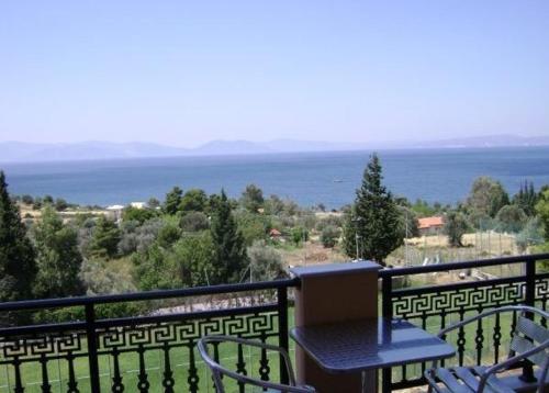 a balcony with a table and chairs and the ocean at Pantheon Hotel & Suites in Nerotriviá