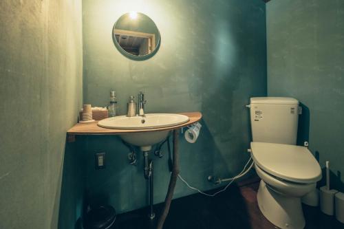 a bathroom with a toilet and a sink and a mirror at Retreat Camp Mahoroba in Fujikawaguchiko
