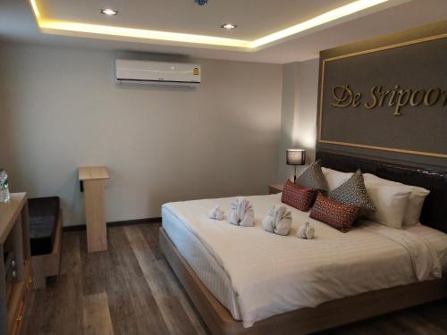 a hotel room with a large bed with white pillows at Hotel De Sripoom in Chiang Mai