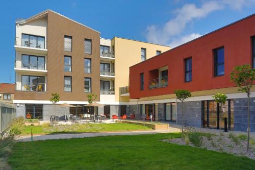 an apartment building with a lawn in front of it at DOMITYS - Le Fil de Soie in Calais