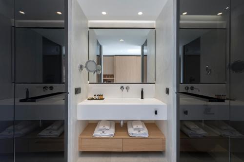a bathroom with a large white sink and a mirror at D' Andrea Lagoon All Suites - Adults Only in Marmari