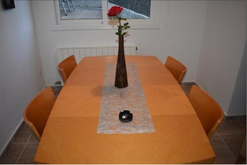 a wooden table with a vase with a rose in it at BEACH HOUSE. CASA CON PISCINA PRIVADA in Calafell