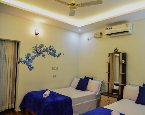 トリバンドラムにあるAmritham Holidays Homestay Trivandrumのベッド2台とソファが備わる客室です。
