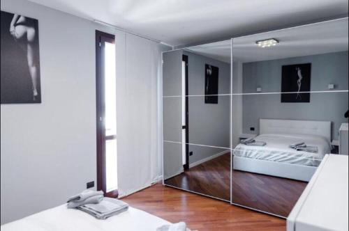 1 dormitorio con espejo y 1 cama. en Le residenze dell'Adda, en Cassano dʼAdda