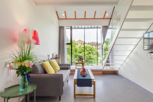 a living room with a couch and a table at Tongli Slowlife River View Inn in Suzhou