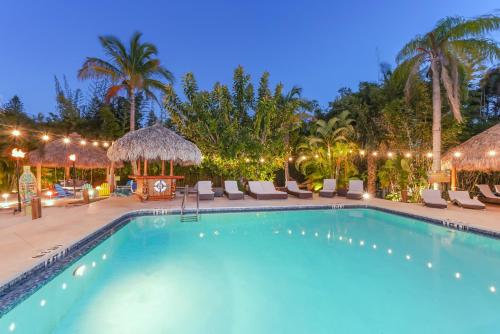 a swimming pool at night with chairs and umbrellas at Siesta Key Palms Resort in Sarasota