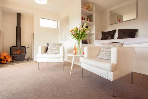 a bedroom with a bed and a chair and a fireplace at The Love Spa in Queenstown