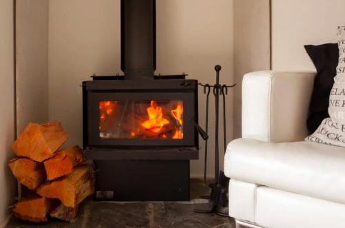 a fireplace in a living room next to a couch at The Love Spa in Queenstown